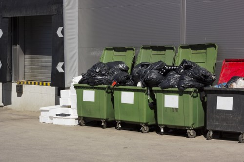 Electric low-carbon van making a commercial waste collection in a town centre